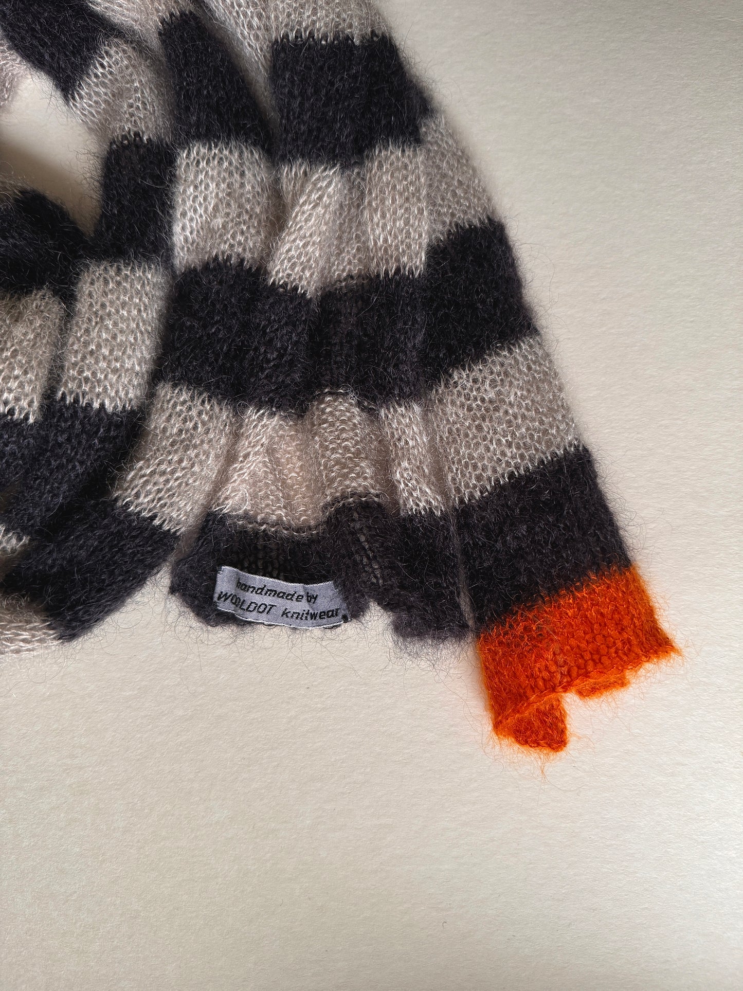 thin skinny long mohair and silk knitted scarf with small orange detail at one end. there is a small wooldot knitwear tag.